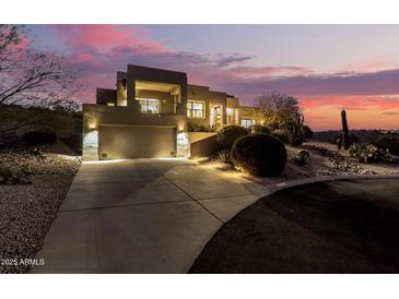 Stunning modern home with a spacious driveway and desert landscaping at twilight at 15501 E Tepee Dr, Fountain Hills, AZ 85268