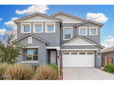 Two-story home with a gray exterior, white trim, a two-car garage, and desert landscaping under a partly cloudy blue sky at 22679 E Estrella Rd, Queen Creek, AZ 85142