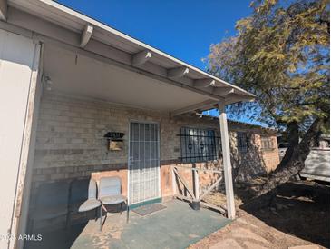 Inviting front porch area with chairs and brick facade under blue skies at 3932 W Bethany Home Rd, Phoenix, AZ 85019