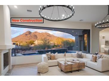 New construction living room with modern lighting, fireplace, mountain view, and a neutral color palette at 6038 E Agave Cir, Carefree, AZ 85377