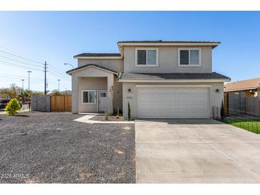 Two-story home featuring stucco siding, a two-car garage, and a front yard with desert landscaping at 9050 S Calle Tomi --, Guadalupe, AZ 85283