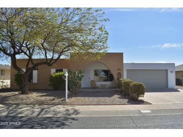 Charming single-story home with desert landscaping, mature tree, and attached two-car garage at 9431 W Timberline Dr, Sun City, AZ 85351