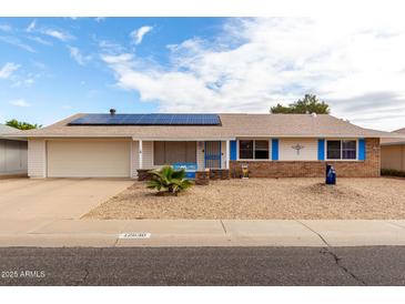 Charming single-story home with solar panels, blue trim, and low-maintenance desert landscaping at 12630 W Crystal Lake Dr, Sun City West, AZ 85375