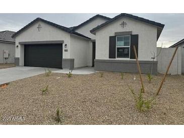 Charming single-story home with a well-maintained front yard and a two-car garage at 1325 S 239Th Dr, Buckeye, AZ 85326