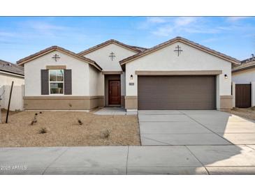 Charming single-story home featuring a desert front yard, a two-car garage, and a covered entryway at 1325 S 239Th Dr, Buckeye, AZ 85326