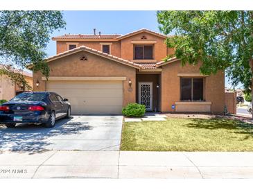 Charming two-story home features a well-maintained front lawn and a two-car garage at 20784 N Marina Ave, Maricopa, AZ 85139