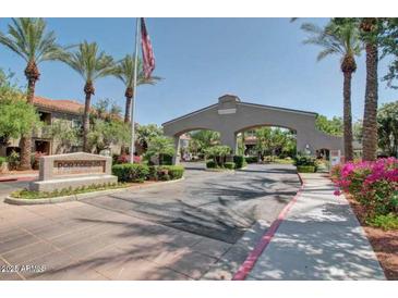 Welcoming entrance with lush landscaping and monument sign at Portofino Condominiums under a clear blue sky at 3830 E Lakewood E Pkwy # 3014, Phoenix, AZ 85048