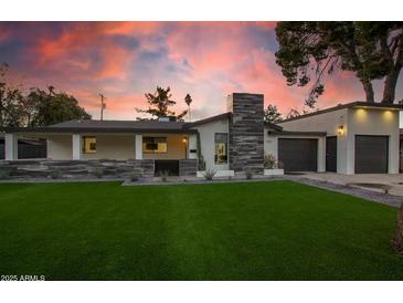 Stunning single-story home featuring meticulous landscaping and a striking stone facade, complemented by a lush lawn at 4132 N 34Th Pl, Phoenix, AZ 85018