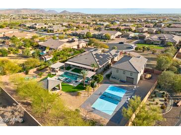 Expansive backyard featuring a pool, pickleball court and mountain views, perfect for outdoor living at 7662 W Artemisa Ave, Peoria, AZ 85383