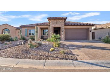 Charming single-story home featuring a desert landscape, stone accents and a tile roof at 7717 W Noble Prairie Way, Florence, AZ 85132