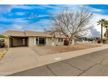 Charming single-story home featuring desert landscaping, covered parking and a welcoming entrance at 8608 E Vernon Ave, Scottsdale, AZ 85257