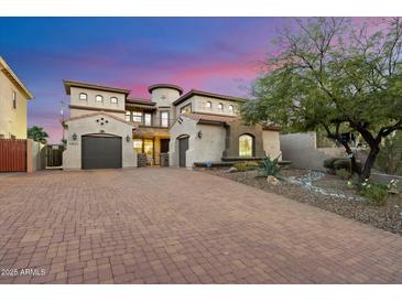 Beautiful stucco home with a large brick driveway and two car garage, surrounded by mature landscaping at 10829 N 11Th Pl, Phoenix, AZ 85020