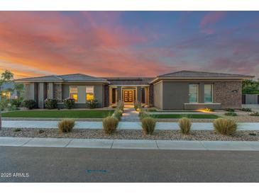 Elegant home boasts professional landscaping, stone accents, and a well-lit path leading to the front door at 19912 E Natalie Way, Queen Creek, AZ 85142