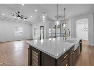 Bright kitchen with a large island featuring quartz countertops, stainless steel appliances, and modern lighting at 21442 E Excelsior Ave, Queen Creek, AZ 85142