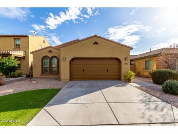 Charming single-story home featuring a two-car garage, desert landscaping and a welcoming facade at 227 E Carob Dr, Chandler, AZ 85286