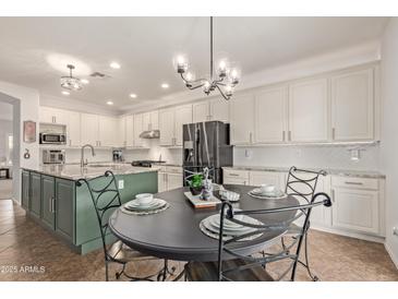 Elegant kitchen with center island, granite countertops, and decorative lighting at 44560 W Copper Trl, Maricopa, AZ 85139
