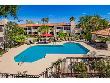 Community pool featuring lounge chairs, lush landscaping, and a clear blue swimming area at 9990 N Scottsdale Rd # 2049, Paradise Valley, AZ 85253