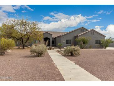 A well-maintained home featuring desert landscaping and a pathway leading to a covered front porch at 10203 N Burris Rd, Casa Grande, AZ 85122