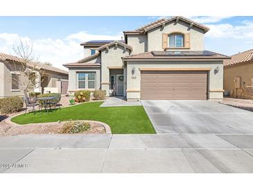 Two-story home features a well-manicured lawn, desert landscaping, and a two-car garage at 10840 W Saddlehorn Rd, Peoria, AZ 85383