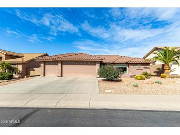 Charming single-story home featuring a three car garage and desert landscaping at 11056 E Nopal Ave, Mesa, AZ 85209