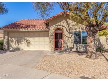 Charming single-story home featuring a terra cotta tile roof and a two-car garage at 12601 S Tonto Ct, Phoenix, AZ 85044