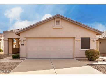 Beige two-car garage in front of a home with neutral tones and desert landscaping beneath a partly cloudy sky at 2429 E Valencia Dr, Casa Grande, AZ 85194