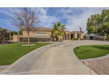 Expansive driveway leading up to the inviting desert home with well manicured landscaping at 4915 N Greentree Dr, Litchfield Park, AZ 85340