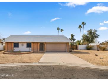 Charming single-story home with a well-maintained front yard and a two-car garage, under a sunny blue sky at 4939 W Joyce Cir, Glendale, AZ 85308