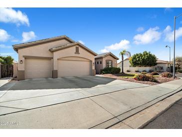 Charming single-Gathering home featuring a three-car garage, desert landscaping, and a neatly manicured lawn at 7161 W Saddlehorn Rd, Peoria, AZ 85383