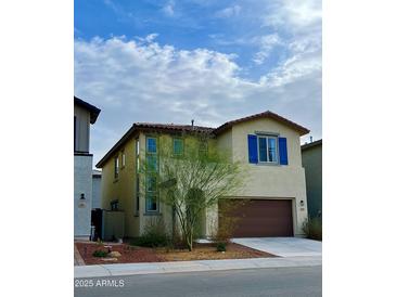 Two-story home with a brown garage door, blue shutters, and desert landscaping at 2079 N Marketside Ave, Buckeye, AZ 85396