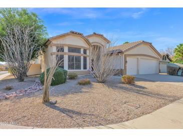 Charming single-story home featuring desert landscaping, a two-car garage, and a neutral-toned exterior at 605 W Michigan Ave, Phoenix, AZ 85023