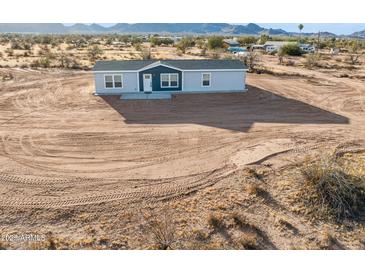 Charming single-story home featuring a modern blue door and gray exterior paint at 164 S Oak Rd, Maricopa, AZ 85139