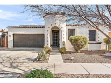 Charming stucco home featuring a brown tile roof, arched entry, and low maintenance desert landscaping at 22788 E Via Las Brisas --, Queen Creek, AZ 85142