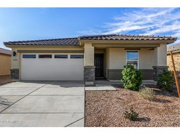 Charming single-story home featuring a two-car garage, desert landscaping and a tile roof at 24531 W Cocopah St, Buckeye, AZ 85326