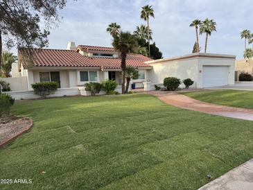 Inviting single-story home with a red-tiled roof, lush lawn, and charming brick pathway leading to the front door at 2701 E Lockwood St, Mesa, AZ 85213