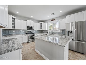 Modern kitchen with white cabinetry, granite countertops, stainless steel appliances, and an island at 40975 N Arbor Ave, San Tan Valley, AZ 85140