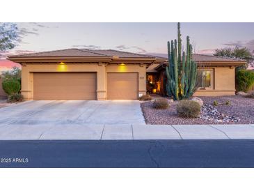 Charming home featuring a three-car garage, desert landscaping, and a striking saguaro cactus at 42019 N Golf Crest Rd, Anthem, AZ 85086