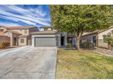 Charming two-story home with a well-maintained lawn and a large tree providing shade at 504 E Quentin Ln, San Tan Valley, AZ 85140