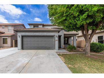 Charming two-story home featuring a well-maintained front yard, a two car garage and mature landscaping at 504 E Quentin Ln, San Tan Valley, AZ 85140