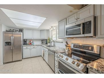 Well-lit kitchen featuring stainless steel appliances and granite countertops at 6251 E Hannibal St, Mesa, AZ 85205