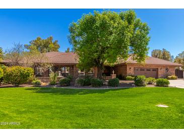 Charming single-story home with lush green lawn, mature trees, and brick exterior at 8649 S Willow Dr, Tempe, AZ 85284
