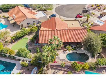 Beautiful aerial view of the property showcasing a private pool and green putting range at 10500 E Mission Ln, Scottsdale, AZ 85258