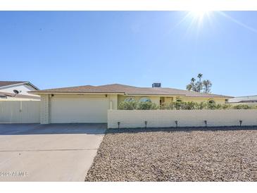 Charming single-story home featuring a brick accent wall, two-car garage, and desert landscaping at 1201 E Gemini Dr, Tempe, AZ 85283