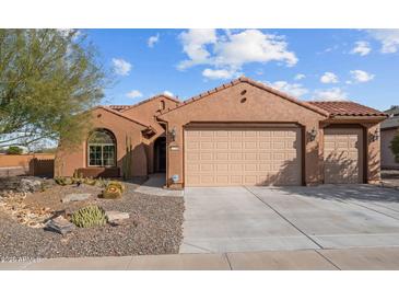 Charming single-story home with a tile roof, a two-car garage and desert landscaping at 27248 W Mohawk Ln, Buckeye, AZ 85396
