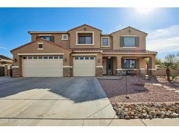 Stunning two-story home featuring a three-car garage and inviting front porch with desert landscaping at 41011 W Walker Way, Maricopa, AZ 85138