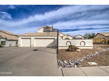 Charming home featuring a two-car garage, basketball hoop and desert landscaping at 6614 E Portia St, Mesa, AZ 85215