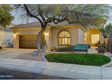 Charming single-story home featuring desert landscaping, a tiled roof, and a cozy front bench at 11919 E Del Timbre Dr, Scottsdale, AZ 85259