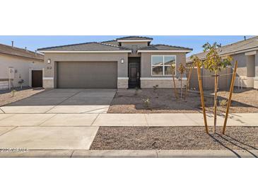 Charming single-story home with a gray exterior, well-kept landscaping, and a two-car garage at 15397 W Hackamore Dr, Surprise, AZ 85387