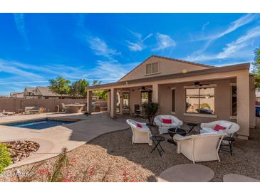 Inviting backyard featuring a covered patio, pool, fire pit, and outdoor seating area perfect for entertaining at 15788 W Sierra St, Surprise, AZ 85379