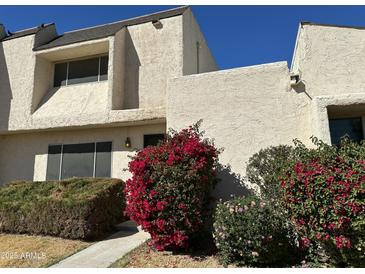 Charming townhouse with a stucco facade and vibrant bougainvillea bushes at 2233 W Farmdale Ave # 2, Mesa, AZ 85202